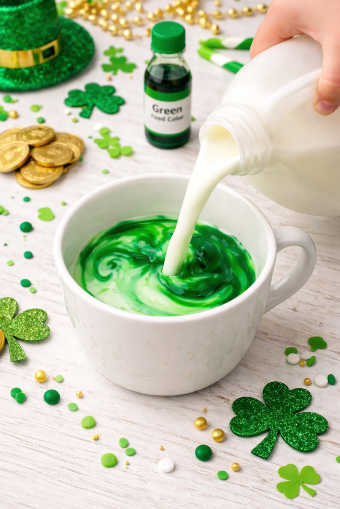 Milk swirling green in a cup from hidden food coloring creating a St. Patrick’s Day leprechaun surprise for kids.